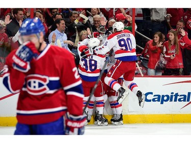 Andre Burakovsky #65 of the Washington Capitals celebrates with his teammates after scoring his first career NHL goal in the first period against the Montreal Canadiens during the Capitals NHL season opener at Verizon Center on October 9, 2014 in Washington, DC.