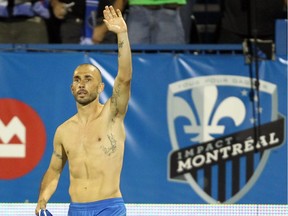 Impact striker Marco Di Vaio waves to fans as he celebrates after scoring a goal during a game against D.C. United by taking off his jersey at Saputo Stadium on Aug. 17, 2013.