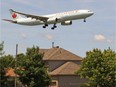 An Air Canada plane flies over houses on Marler Ave. in Dorval on its final approach to Pierre Elliot Trudeau Airport in Montreal, Sunday June 15, 2014.