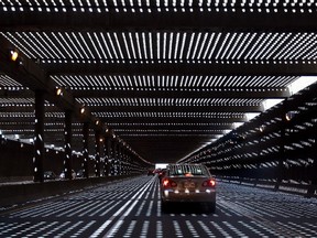 Light dapples onto traffic through the paralumes of the north bound lane of Highway 13 in Ville St Laurent in  June 2012.