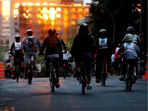 The last rays of sun hit Montreal buildings as cyclists take part in the Tour la Nuit, the night edition of the Tour de L'lle in Montreal on Friday May 30, 2014.