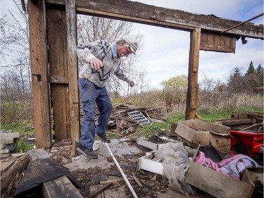 Roger Brabant bends metal pipe he will reclaim as he disassemble a barn Monday, October 27, 2014.