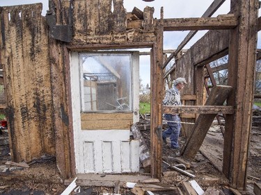 Roger Brabant walks through a disassembled barn as he works to reclaim some of the wooden beams and planks.