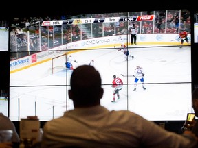 Sports fans watch the Canadiens play the Chicago Blackhawks at the Bell Centre's Cage aux Sports in Montreal on Oct. 1, 2014.