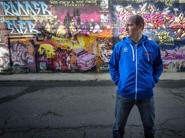 Graphic artist Mike Vallee poses in front of a graffiti wall near his business on Notre-Dame St. in Lachine. Tuesday, October 14, 2014.