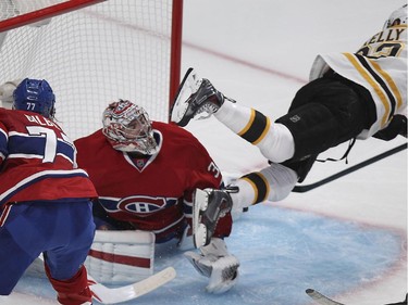 Boston Bruins Chris Kelly flies past Montreal Canadiens goalie Carey Price and defenceman Tom Gilbert during National Hockey League game in Montreal Thursday October 16, 2014.