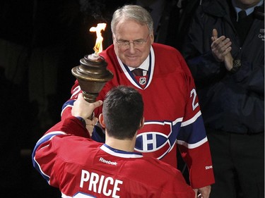 Former Montreal Canadiens goaltender Ken Dryden passes the torch to current Hab Carey Pice during ceremony prior to home opener against the Boston Bruins in Montreal Thursday October 16, 2014.