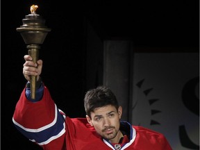 Canadiens goalie Carey Price raises the torch during ceremony before team's home opener at the Bell Centre on Oct. 16, 2014.