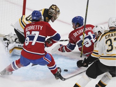 The puck slides to Montreal Canadiens  Max Pacioretty from rebound on David Desharnais shot in front of Boston Bruins goalie Tuukka Rask during National Hockey League game in Montreal Thursday October 16, 2014.  Pacioretty put the puck in the net for a goal.  Bruins defencemen Zdeno Chara and Adam McQuaid find themselves out of position.