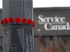 A dozen  poppies were placed  by a soldier on a lamp post in the parking lot a few feet from where one soldier was killed and an other  wounded in a hit and run. Provincial police continue to investigate Tuesday October 21, 2014, after the suspect in the hit and run  was shot dead by Laval police in St-Jean-sur-Richelieu October 20. Police pursued the suspect from the scene until his car flipped, he got out, and was shot.