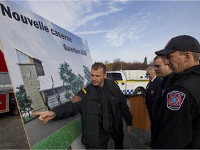 Fire chief Alain Letarte points to a drawing of a new fire station as Regent Marineau, centre, Ian Casa and Phillip Bellefeuille, look on.
