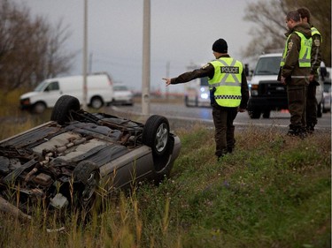 Sureté du Québec police investigators go over the scene of a police shooting in Saint-Jean-sur-Richelieu near Montreal on Monday Oct. 20, 2014.