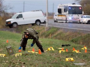 Police investigators go over the scene of a police shooting in Saint-Jean-sur-Richelieu on Monday, Oct. 20, 2014.