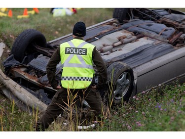Sûreté du Québec police investigators look over the flipped car of a suspect after a police car chase and shooting in Saint-Jean-sur-Richelieu near Montreal on Monday October 20, 2014. A motorist ran over two soldiers and fled the scene, when confronted by police he is alleged to have been holding a knife when he was shot dead by police. The incident has raised questions over the threat of homegrown terrorism.