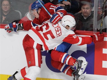 Brendan Gallagher of the Montreal Canadiens is hit by Danny DeKeyser of the Detroit Red Wings in NHL action at the Bell Centre in Montreal on Tuesday, October 21, 2014.