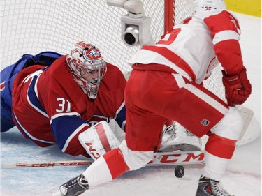 Goalie Carey Price of the Montreal Canadiens pushes a puck away from  Tomas Jurco of the Detroit Red Wings in Montreal, on Tuesday, October 21, 2014 in the first period of NHL action at the Bell Centre.