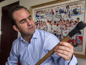 Canadiens owner, president and CEO Geoff Molson reads the famous names like Jean Béliveau and Henri Richard on one of his favourite hockey sticks in his office at the Bell Centre on Oct. 21, 2014.