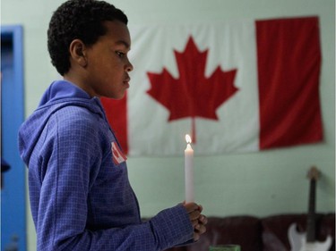 Marlon Kis-Ariwei holds a candle during a vigil at the Boys and Girls Club of Lachine.