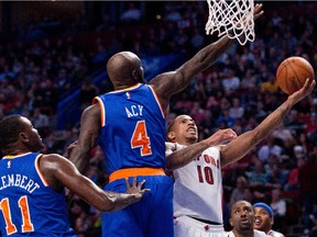 Toronto Raptors guard DeMar DeRozan, right, struggles to get the ball to the net as New York Knicks forward Quincy Acy and New York Knicks centre Samuel Dalembert, left, try to block him during a preseason NBA game in Montreal on Friday, Oct, 24, 2014.