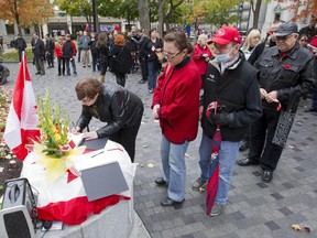 People stand in line to sign a book of condolences at Dorchester Square in Montreal, Saturday, October 25, 2014, during tribute to Warrant Officer Patrice Vincent and Cpl. Nathan Cirillo, both members of the Forces who were attacked and killed in Canada this week.