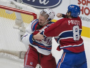 The shoulder pads of New York Rangers Kevin Klein go flying during a fight with  Montreal Canadiens Brandon Prust during 2nd period NHL action in Montreal  on Saturday, October 25, 2014.
