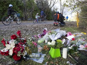 Cyclists and pedestrians go past a makeshift memorial on a path in Longueuil on Sunday, Oct. 26, 2014, to honour Jenique Dalcourt, who died after being found beaten on the path Oct. 21.