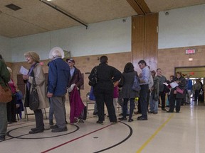 Voters lined up and waited as long as 90 minutes to vote at St. Monica Elementary School during the advance polls for school board elections in Montreal on Sunday, Oct. 26, 2014.