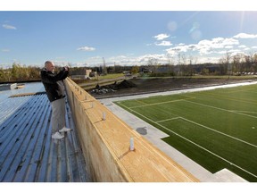 Property developer Philipp Schumacher takes a photo at the site of  the new turf field and steel frame, two-storey structure that will be a new sports dome in Baie d'Urfe Monday, October 28, 2013.