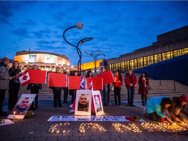 Girls light candles to spell out Canada during a vigil organized by Arab-Canadian women to honour slain soldiers Corporal Nathan Cirillo and Warrant Officer Patrice Vincent at Place des Arts in Montreal on Tuesday, Oct. 28, 2014.