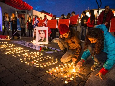 Girls light candles to spell out Canada during a vigil organized by Arab-Canadian women to honour slain soldiers Corporal Nathan Cirillo and Warrant Officer Patrice Vincent at Place des Arts in Montreal on Tuesday, Oct. 28, 2014.