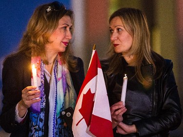 Nahd Alshawa, left, originally from Palestine, and Gunnar Mousa, right, originally from Syria, take part in a candle-light vigil organized by Arab-Canadian women to honour slain soldiers Corporal Nathan Cirillo and Warrant Officer Patrice Vincent at Place des Arts in Montreal on Tuesday, Oct. 28, 2014.