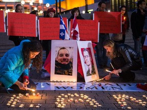 Women light candles during a vigil organized by Arab-Canadian women to honour slain soldiers Corporal Nathan Cirillo and Warrant Officer Patrice Vincent at Place des Arts in Montreal on Tuesday, Oct. 28, 2014.