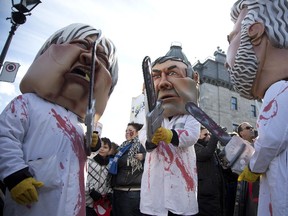 Liberal ministers use chainsaws to produce cuts, as people dressed up for Halloween at an anti-austerity march in downtown Montreal, Friday morning.