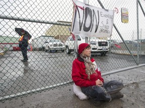 Alyssa Symons Belanger is chained to the gate at the entrance to a refinery in Montreal, Oct. 7, 2014. She was one of four people protesting against pipeline projects.
