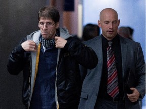 53-year-old Frank Rubert, left, is escorted from a courtroom by an unidentified Montreal police officer Oct. 8, 2014. Rubert was testifying at Luka Magnotta's first degree murder trial, having connected with the accused on GayRomeo.com at the end of May 2012.