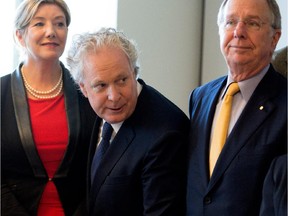 Former Quebec premier Jean Charest (centre), seen in an October 2014 file photo, says the report reconstructs events of 12 years ago in a "tendentious" manner.