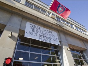 A banner hanging outside a fire station in Ville St Laurent, Montreal, Thursday, September 25, 2014, similar to others at fire stations around the city. The banner denounces the suspension of 35 firefighters following a rowdy protest at Montreal city hall.