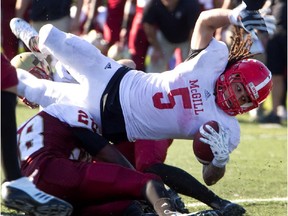 McGill Redmen Luis Guimont-Mota gets hit by Concordia Stingers Neil Riley-Grant, bottom, during the 27th annual Shrine Bowl football game in Montreal on Saturday, September 28, 2013. McGill won the game 53-52 in overtime.