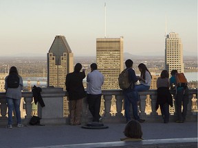 People watching a scenic view of Montreal skyline from the Mount-Royal mountain in Montreal.