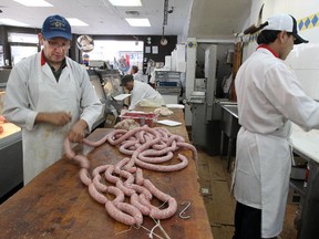 Butcher Jose Rojas, left, ties off sausage at Boucherie St-Viateur in the Beaubien/St-Laurent neighbourhood in Montreal on Sept. 30, 2014.