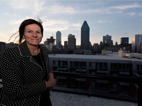 Guylaine Tremblay  stands on the roof top terrace with a view of the city skyline at her and her partner, Guy Tessier's, not seen, Griffintown condo in Montreal on Tuesday Sept. 30, 2014.