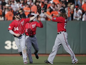 Washington Nationals Bryce Harper, left, Denard Span and Jayson Werth, right, celebrate after they beat the San Francisco Giants 4-1 during Game 3 of baseball's NL Division Series in San Francisco, Monday, Oct. 6, 2014.