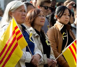 Members of Montreal’s South Vietnamese community hold the flag of South Vietnam during a solidarity protest to support democracy in Hong Kong, held at McGill University in Montreal on Wednesday, Oct. 1, 2014. The flag is "often used by Vietnamese who fled the communist regime and sometimes used as a sign of protest against communism," one person said.