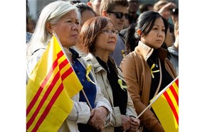 Members of Montreal’s South Vietnamese community hold the flag of South Vietnam during a solidarity protest to support democracy in Hong Kong, held at McGill University in Montreal on Wednesday, Oct. 1, 2014. The flag is "often used by Vietnamese who fled the communist regime and sometimes used as a sign of protest against communism," one person said.