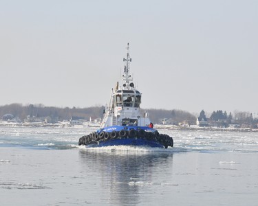 A sunny day brings out the Icebreaker getting the river ready for Spring