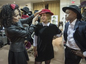 Ophelie Hats designer Corine Serruya, left, adjusts a hat on Isabelle Gregoire, centre, as Ruby Thelot looks on at the Grande Braderie de mode quebecoise, which is in  its 40th edition and 20th year in Montreal, on Tuesday, October 21, 2014.