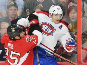 Ottawa Senators’ Chris Neil, left, hits Canadiens’ Max Pacioretty into the boards during first period of a preseason NHL hockey game in Ottawa, Ontario, on Friday, Oct. 3, 2014.