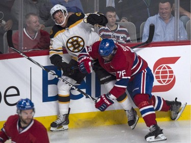 Boston Bruins' Chris Kelly is checked into the boards by Montreal Canadiens' P.K. Subban during first period NHL hockey action Thursday, October 16, 2014 in Montreal.