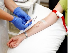 A medical professional administers medication via IV.