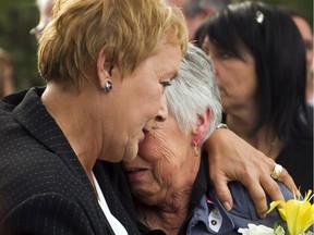 Then-Quebec Premier-elect Pauline Marois, left, comforts Ginette Jean, mother of Denis Blanchette, during funeral services Monday, Sept. 10, 2012, in Montreal.